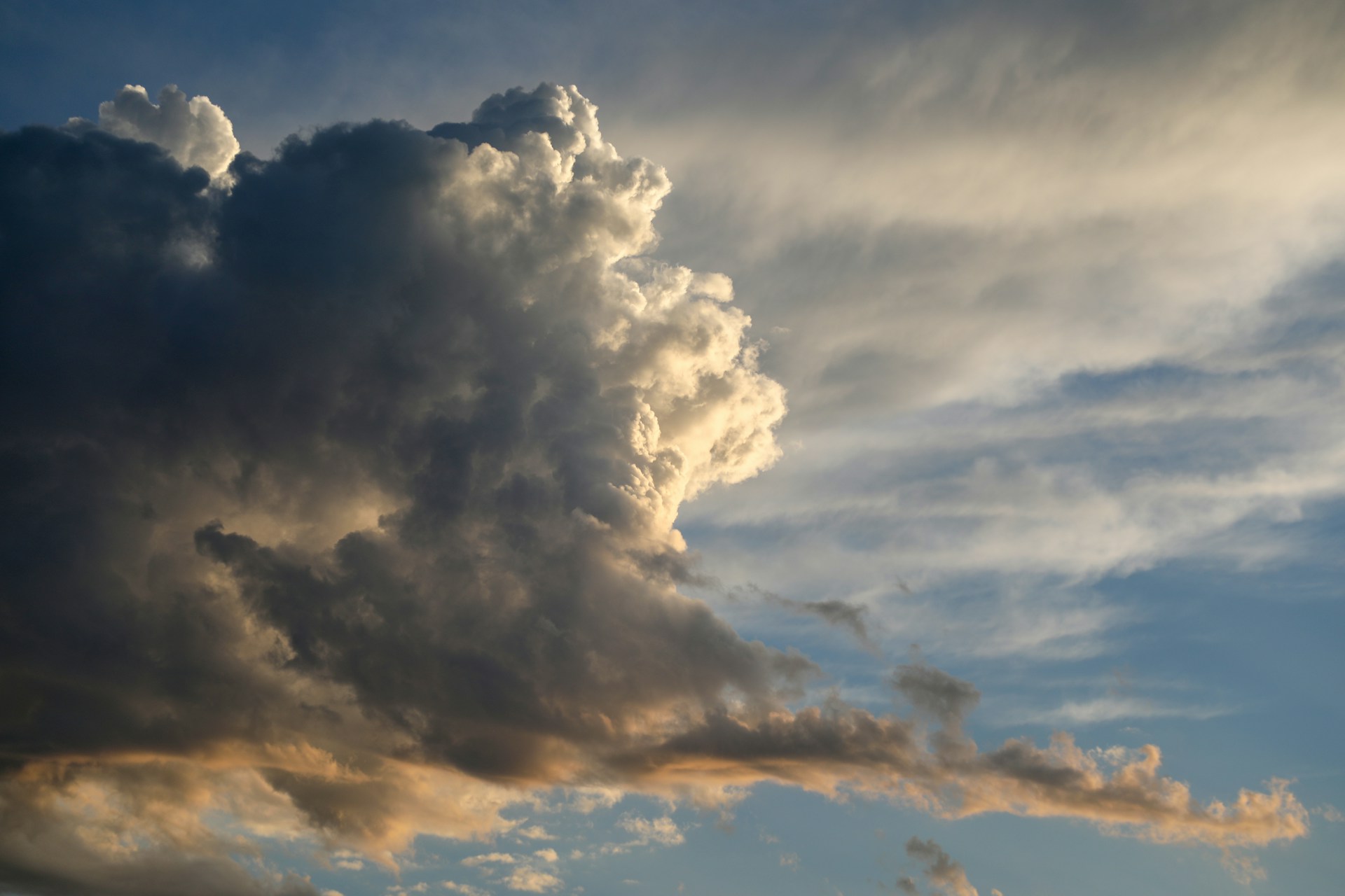 right-lit clouds in grey and gold, blue sky