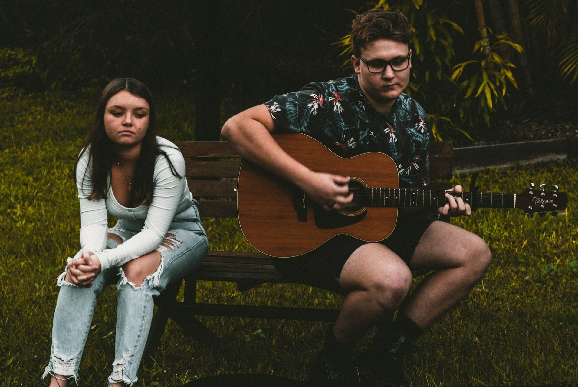 bored looking teen girl awkwardly serenaded by teen boy with guitar