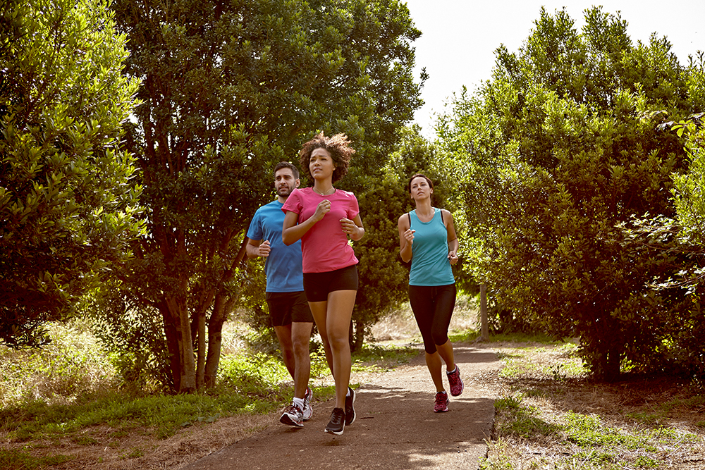 three joggers run in park